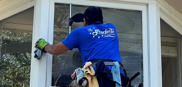 A Starbrite cleaner washing a residential window